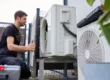 Techniker installiert eine Luft-Wasser-Wärmepumpe an einem modernen Fertighaus in Österreich